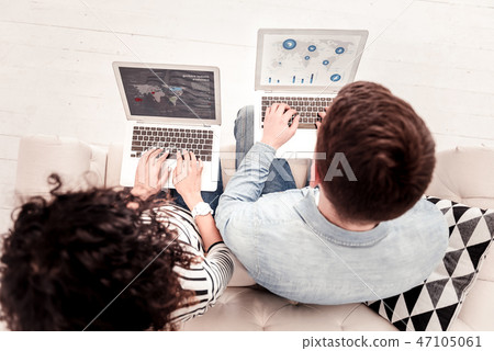 Smart young people looking at their laptop screens 47105061