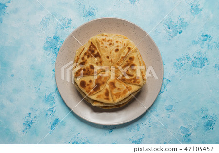 Moldovan Placinta on a plate on a blue table. 47105452