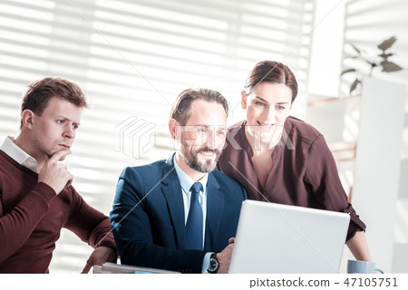Glad three colleagues conducting meeting 47105751
