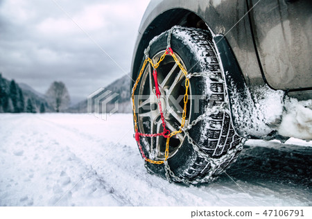 Snow chains on tire. Detail of wheel on wimter roa 47106791
