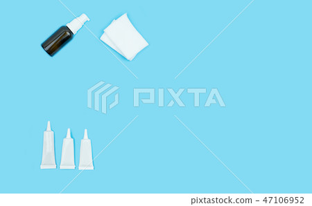 Blank bottle and skin cream tube on blue Blank bottle and skin cream tube on blue 47106952