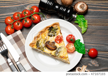 Slice of traditonal homemade spinach chicken quiche tart or pie on plate 47107103