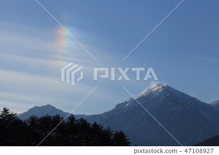 Vertical rainbow in horizontal streaked clouds 47108927