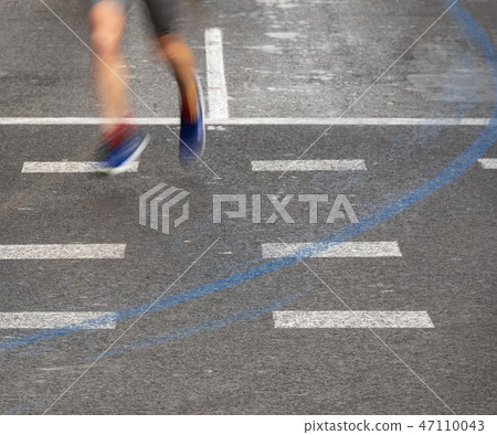 Runner legs blurred motion following blue line Runner legs blurred motion following blue line 47110043