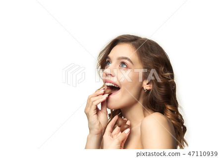 beauty portrait of a cute girl in act to eat a chocolate candy 47110939