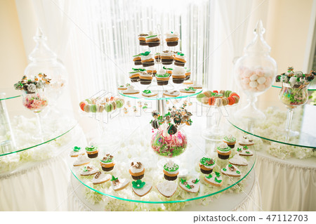 Delicious and tasty dessert table with cupcakes shots at reception closeup 47112703