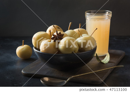 Pickled apples in bowl and apple sidr on dark. 47113100
