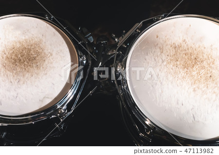 Closeup view of a drum set in a dark studio. Black drum barrels with chrome trim. The concept of Closeup view of a drum set in a dark studio. Black drum barrels with chrome trim. The concept of 47113982