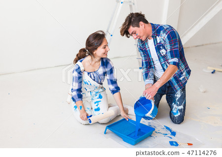 People, redecoration and renovation concept - Horizontal portrait of couple pour paint People, redecoration and renovation concept - Horizontal portrait of couple pour paint 47114276