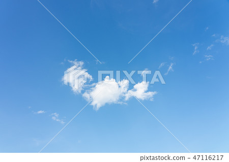 The sky is bright blue. There are clouds floating 47116217