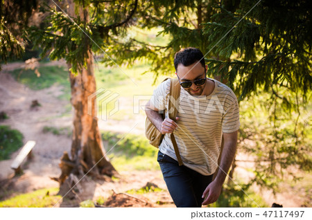 Man using hiking with backpack outdoors in woods Man using hiking with backpack outdoors in woods 47117497