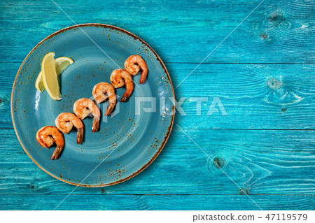 Appetizing shrimps on a blue plate Appetizing shrimps on a blue plate 47119579
