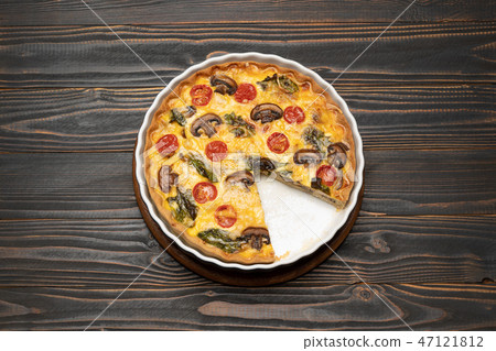 Baked homemade quiche pie in ceramic baking form on concrete background Baked homemade quiche pie in ceramic baking form on concrete background 47121812