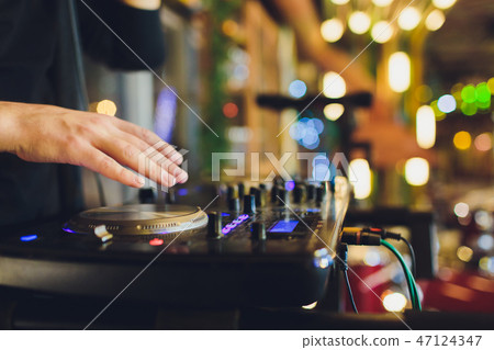 DJ playing music at mixer closeup and mixes the track in the nightclub at party. DJ playing music at mixer closeup and mixes the track in the nightclub at party. 47124347