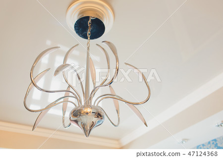 Close-up of a beautiful crystal chandelier Beautiful chandelier. luxury expensive chandelier hanging Close-up of a beautiful crystal chandelier Beautiful chandelier. luxury expensive chandelier hanging 47124368