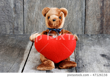 Toy bear doll and the jewelry ring with red heart. 47126138