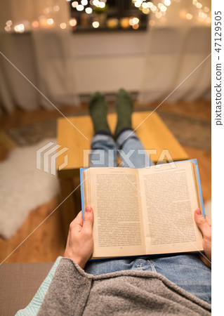 close up of young man reading book at home close up of young man reading book at home 47129505