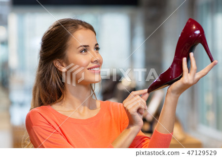 happy young woman choosing shoes at store happy young woman choosing shoes at store 47129529