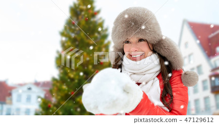 woman with snow over christmas tree at tallinn 47129612