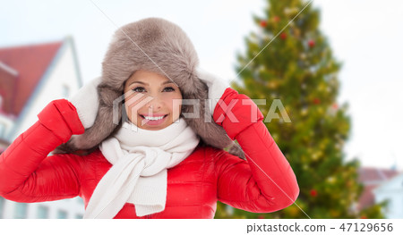 happy woman over christmas tree in tallinn 47129656