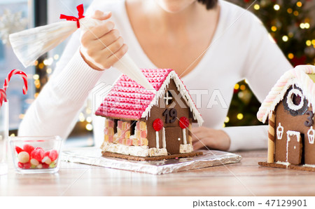 woman making gingerbread houses on christmas 47129901