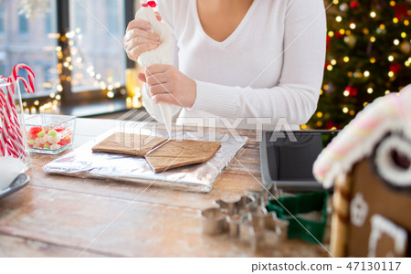 close up of woman making gingerbread house 47130117