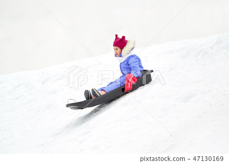 happy little girl sliding down on sled in winter 47130169
