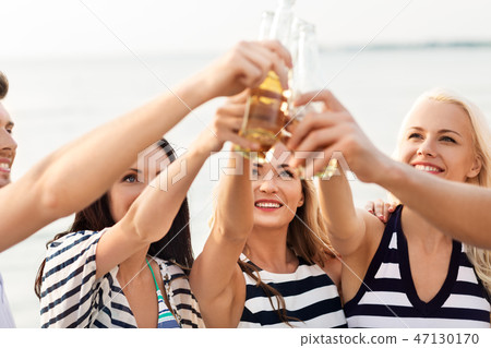 happy friends drinking non alcoholic beer on beach 47130170