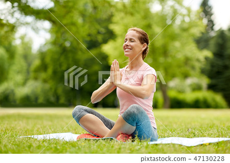 happy woman meditating in summer park 47130228