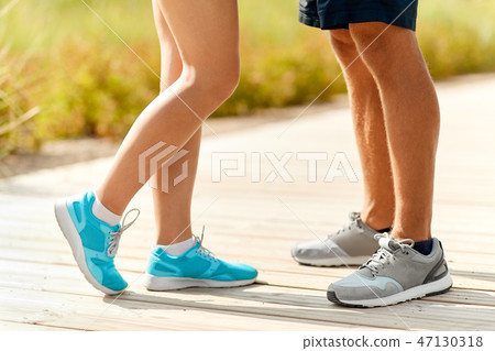 legs of couple of sportsmen in sneakers outdoors 47130318