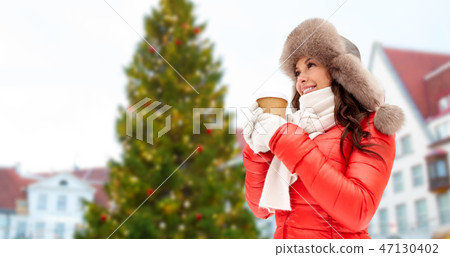 woman with coffee over christmas tree in tallinn woman with coffee over christmas tree in tallinn 47130402