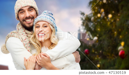 happy couple hugging over christmas tree happy couple hugging over christmas tree 47130519