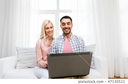 smiling happy couple with laptop at home smiling happy couple with laptop at home 47130521