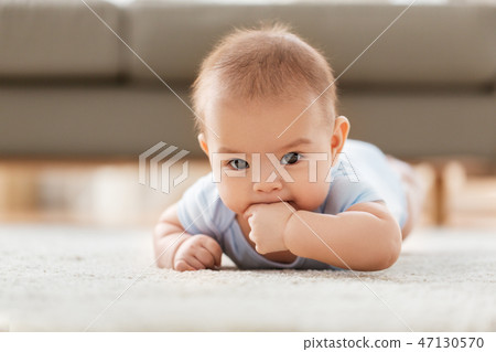 sweet little asian baby boy lying on floor at home sweet little asian baby boy lying on floor at home 47130570