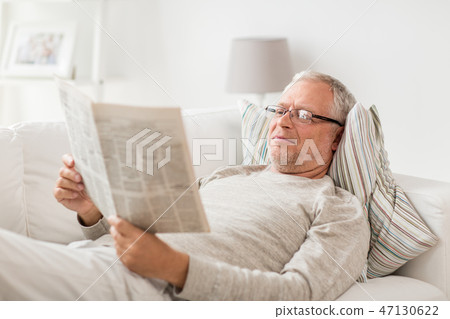 senior man reading newspaper at home senior man reading newspaper at home 47130622