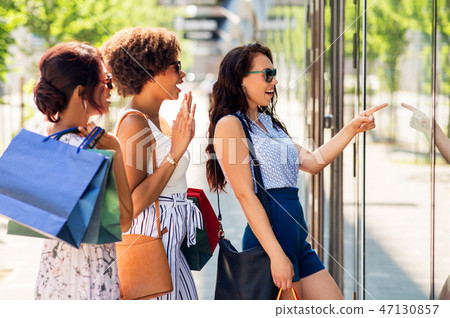 women with shopping bags looking at shop window women with shopping bags looking at shop window 47130857
