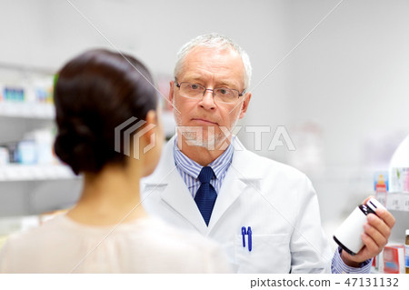 apothecary showing drug to customer at pharmacy 47131132