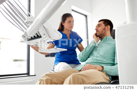 man with toothache and dentist at dental clinic man with toothache and dentist at dental clinic 47131256