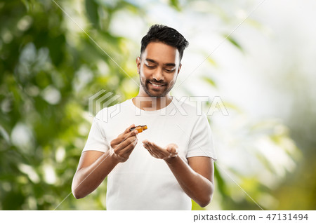 indian man applying grooming oil to his hand indian man applying grooming oil to his hand 47131494