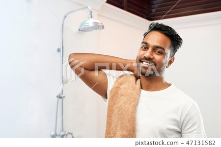smiling indian man with bath towel over shower smiling indian man with bath towel over shower 47131582