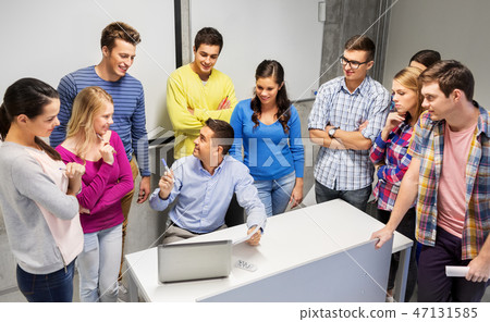 students and teacher with papers and laptop 47131585