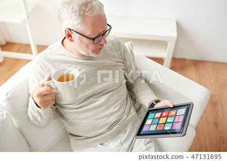 old man with smart home icons on tablet computer old man with smart home icons on tablet computer 47131695