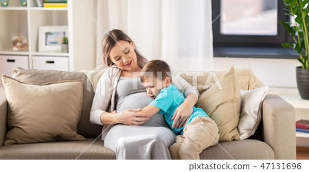 happy pregnant mother and son hugging at home happy pregnant mother and son hugging at home 47131696
