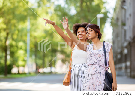 two women or female friends catching taxi at city two women or female friends catching taxi at city 47131862