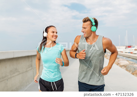 couple with headphones running outdoors couple with headphones running outdoors 47132326