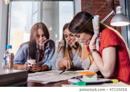Three smiling female students learning together in classroom Three smiling female students learning together in classroom 47135058