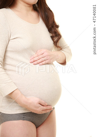 A pregnant woman with a pregnant woman touching his belly 47140081