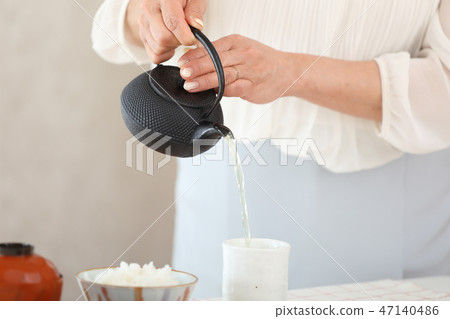 Housewife pouring Japanese tea 47140486