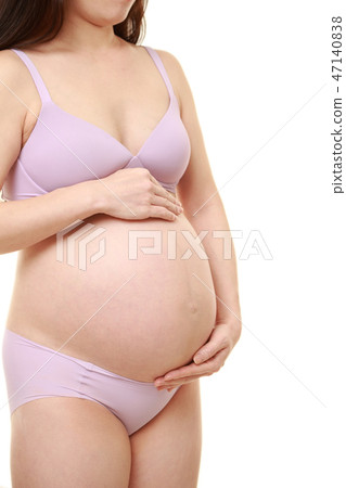把她的手放的一名孕婦在她的胃上 47140838
