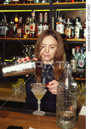 Bartender girl pouring a delicious cocktail Bartender girl pouring a delicious cocktail 47141062